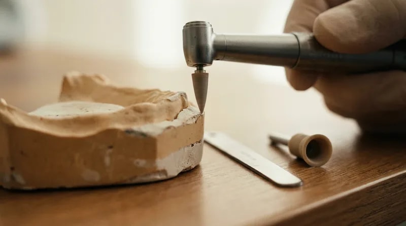 Fine polishing disc and measuring gauge beside a dental model showing how little enamel is reshaped