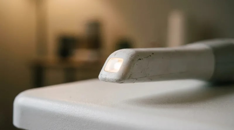 Close-up of an intraoral scanner tip emitting ordinary visible light rather than radiation