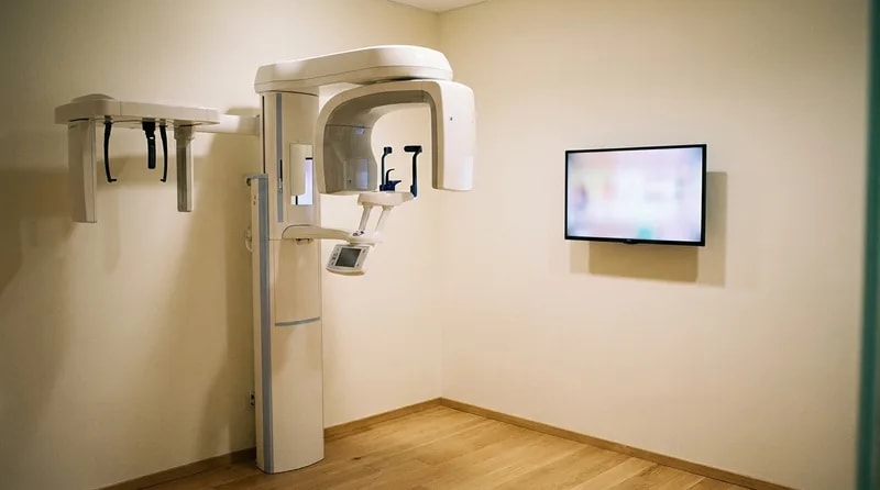Cone beam CT scanner in an imaging room used to map bone depth before implant placement